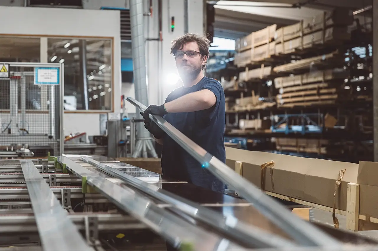 Operator removing an aluminium profile from the line
