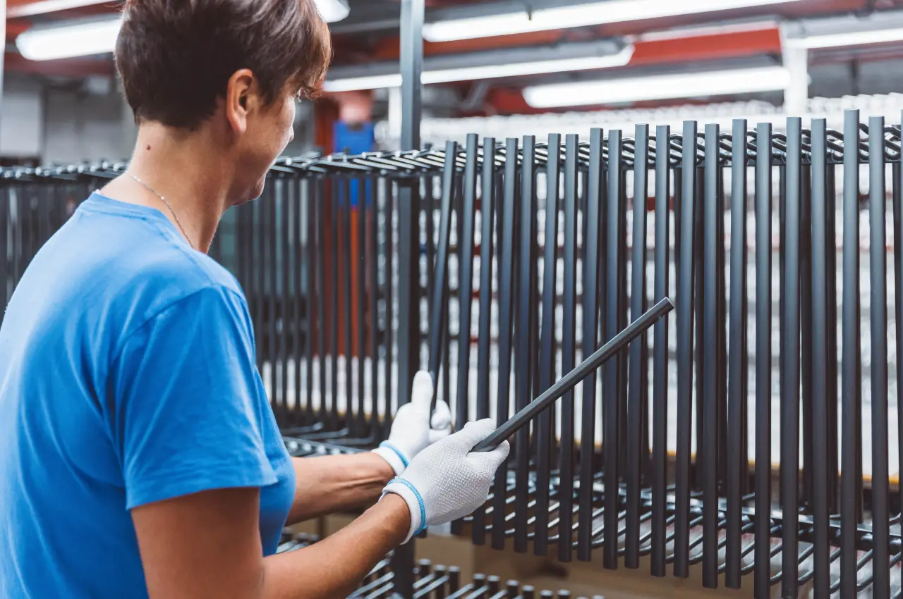 Operator inspecting aluminium components on racks