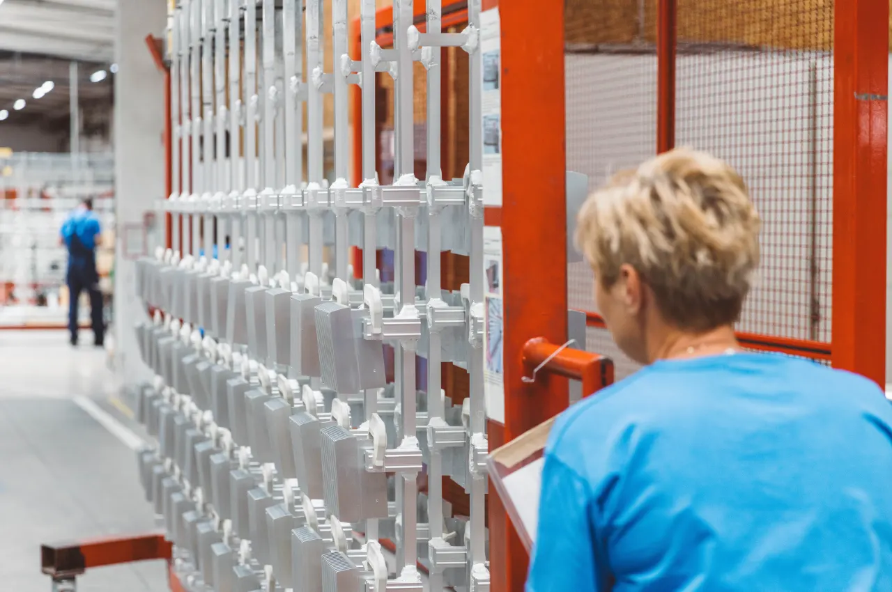 Operator checking aluminium components on racks